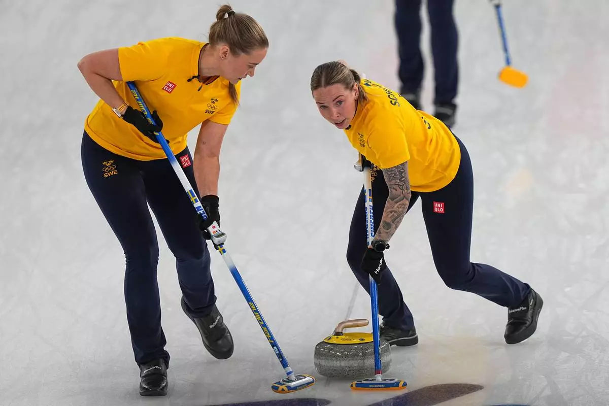 Sweden's Sara McManus, right, and Sofia Scharback compete, during a women's curling semifinal match against at the 2026 Winter Olympics, in Cortina d'Ampezzo, Italy, Friday, Feb. 20, 2026. (AP Photo/Fatima Shbair)