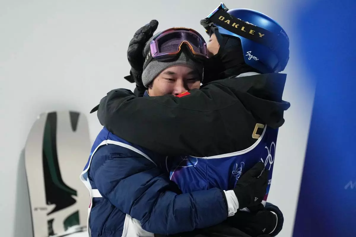 Japan's Kira Kimura, left, celebrates with China's Su Yiming during the men's snowboarding big air finals at the 2026 Winter Olympics, in Livigno, Italy, Saturday, Feb. 7, 2026. (AP Photo/Abbie Parr)
