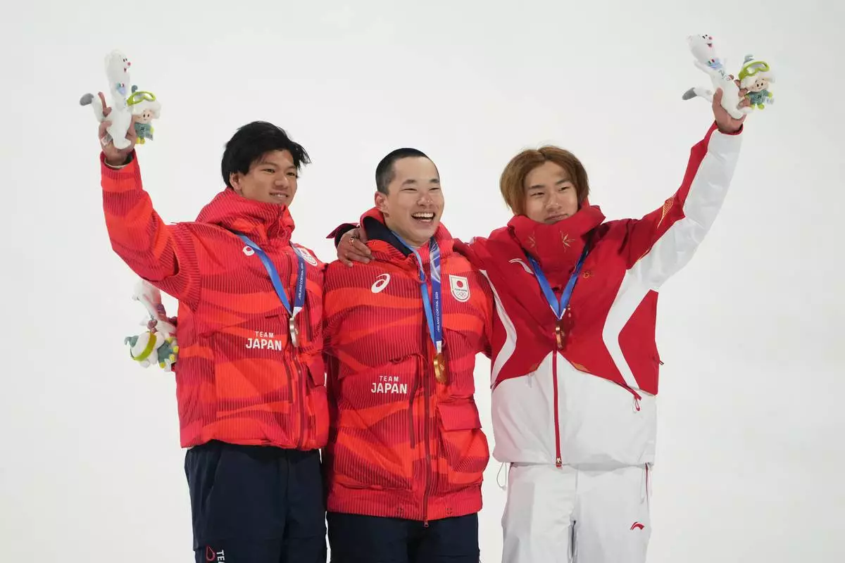 From left, silver medalist Japan's Ryoma Kimata, gold medalist Japan's Kira Kimura and bronze medalist China's Su Yiming celebrate after the men's snowboarding big air finals at the 2026 Winter Olympics, in Livigno, Italy, Saturday, Feb. 7, 2026. (AP Photo/Lindsey Wasson)