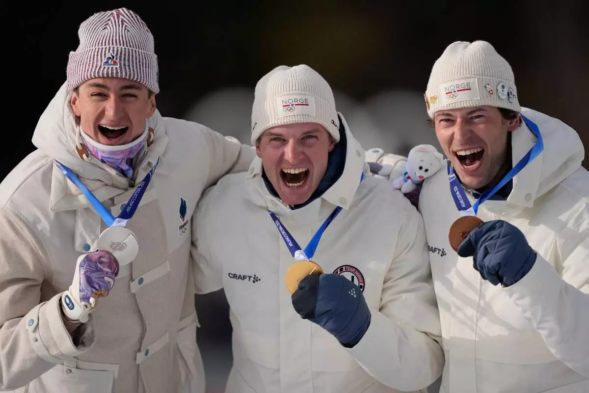 Silver medalist Eric Perrot, of France, from left, gold medalist Johan-Olav Botn, of Norway, and bronze medalist Sturla Holm Laegreid, of Norway, pose after the men's 20-kilometer individual biathlon race at the 2026 Winter Olympics in Anterselva, Italy, Tuesday, Feb. 10, 2026. (AP Photo/Mosa'ab Elshamy)