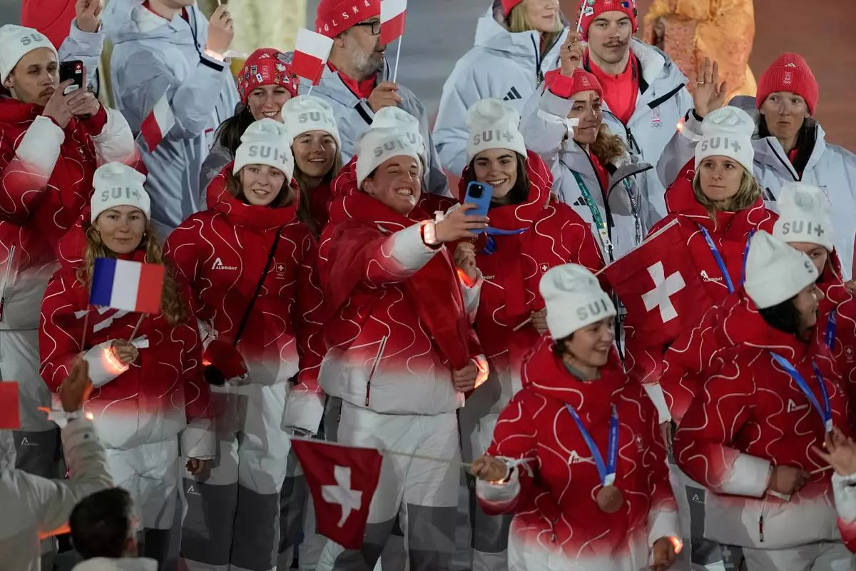 Swiss athletes take a selfie during the closing ceremony of the 2026 Winter Olympics, in Verona, Italy, Sunday, Feb. 22, 2026. (AP Photo/Ashley Landis)
