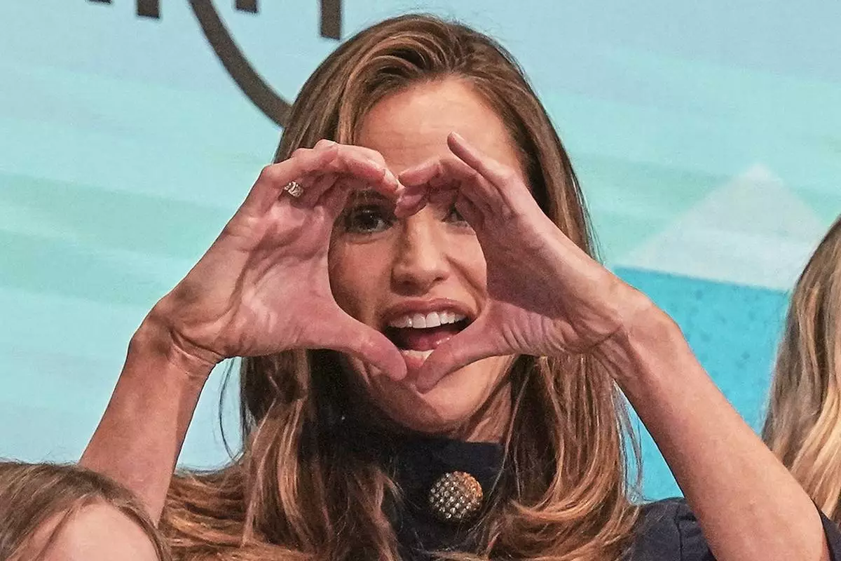 Once Upon a Farm co-Founder Jennifer Garner makes a heart on the New York Stock Exchange podium prior to ringing the opening bell for her company's IPO, Friday, Feb. 6, 2026. (AP Photo/Richard Drew)
