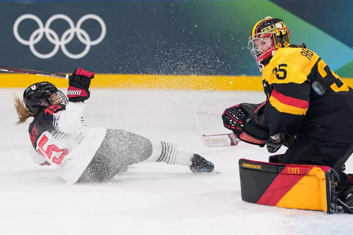 Japan's Rui Ukita, left, slides past Germany's Sandra Abstreiter during a preliminary round match of women's ice hockey between Germany and Japan at the 2026 Winter Olympics, in Milan, Italy, Saturday, Feb. 7, 2026. (AP Photo/Petr David Josek)