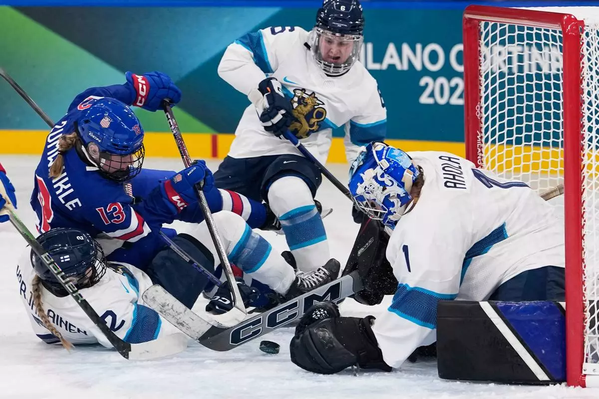 Finland's Sanni Ahola, right, makes a save against United States' Grace Zumwinkle during a preliminary round match of women's ice hockey between the United States and Finland at the 2026 Winter Olympics, in Milan, Italy, Saturday, Feb. 7, 2026. (AP Photo/Petr David Josek)