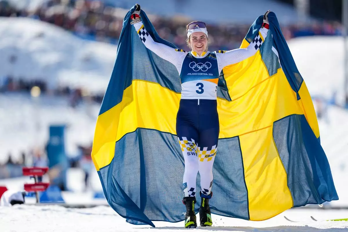 Ebba Andersson, of Sweden, celebrates after winning the gold medal in the cross country skiing women's 50km mass start classic at the 2026 Winter Olympics, in Tesero, Italy, Sunday, Feb. 22, 2026. (AP Photo/Matthias Schrader)