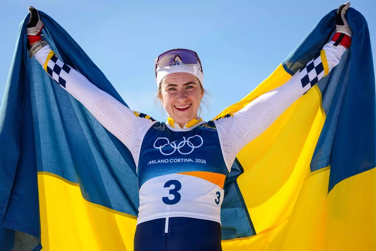 Ebba Andersson, of Sweden, celebrates after winning the gold medal in the cross country skiing women's 50km mass start classic at the 2026 Winter Olympics, in Tesero, Italy, Sunday, Feb. 22, 2026. (AP Photo/Matthias Schrader)