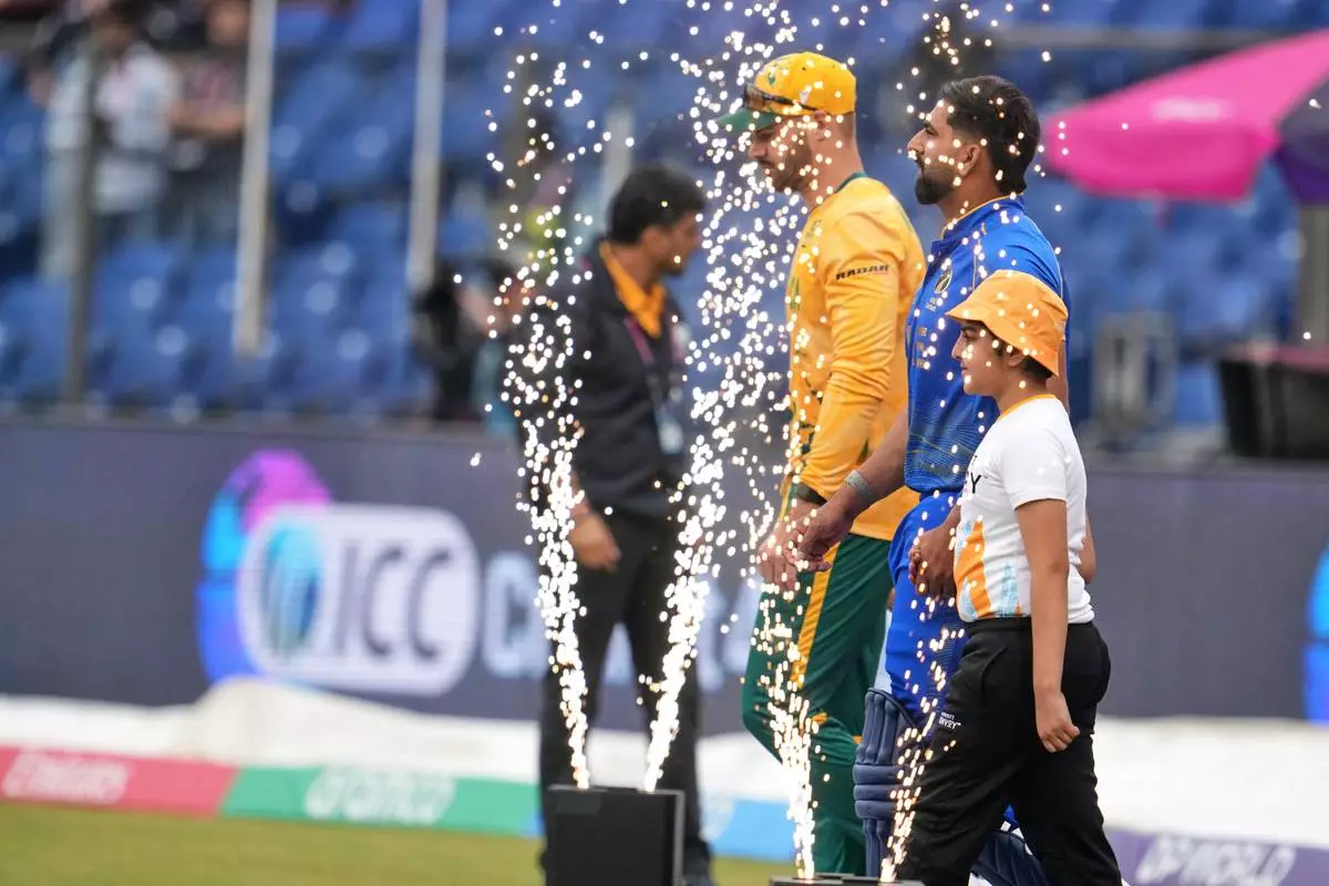 South Africa's David Miller, left, and United Arab Emirates' captain Muhammad Waseem walk into the field before the start of their T20 World Cup cricket match between South Africa and United Arab Emirates in New Delhi, India, Wednesday, Feb. 18, 2026. (AP Photo/Manish Swarup)