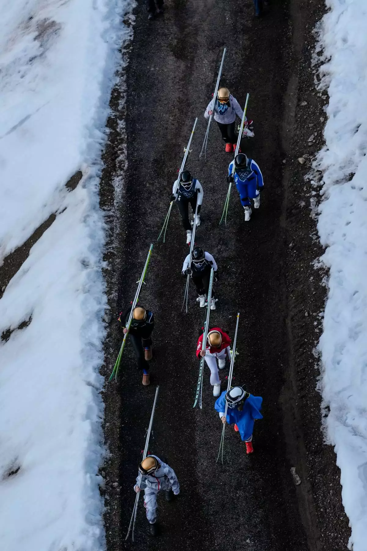 Athletes make their way to the ramp during the ski jumping women's large hill individual at the 2026 Winter Olympics, in Predazzo, Italy, Sunday, Feb. 15, 2026. (AP Photo/Evgeniy Maloletka)