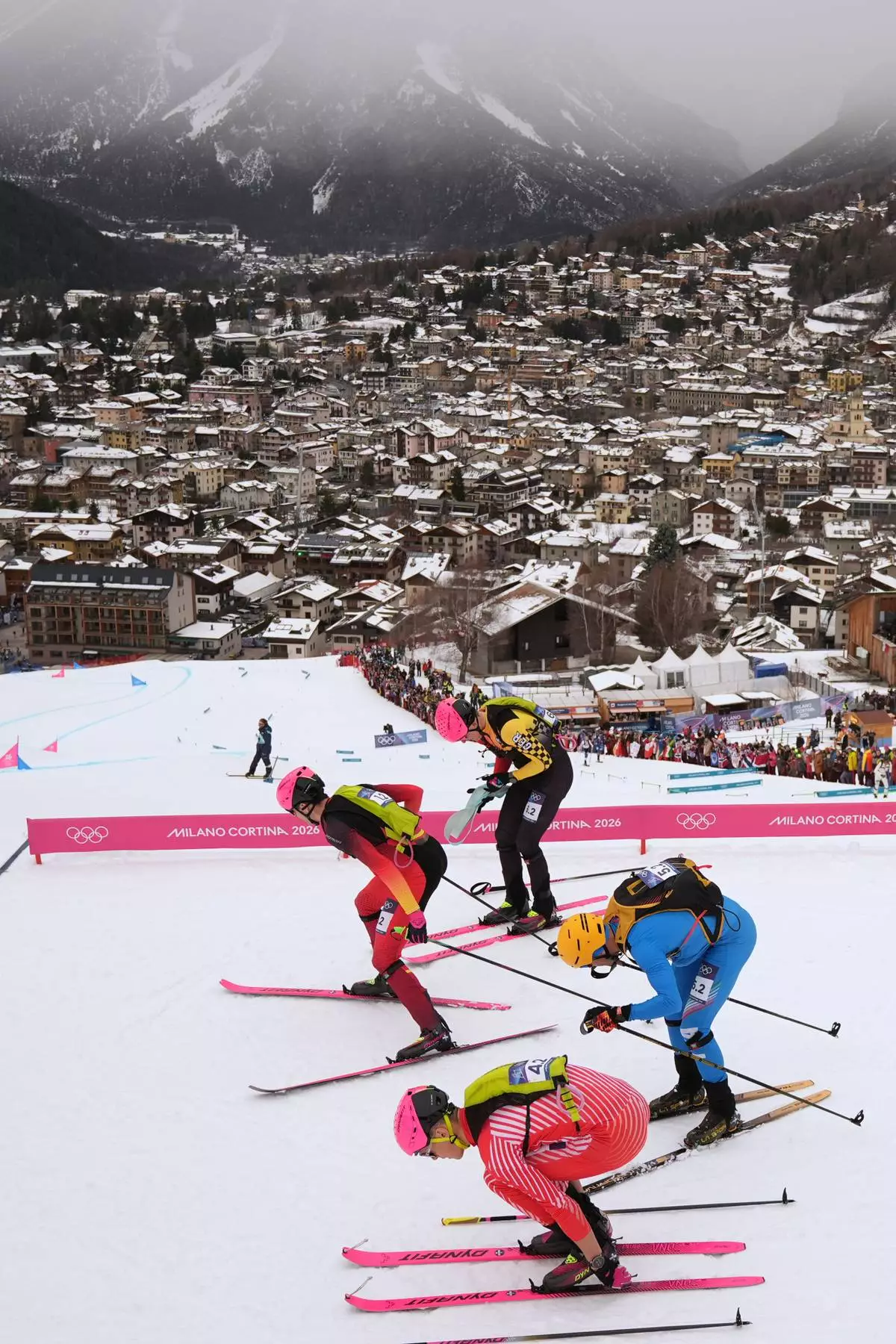 Italy's Michele Boscacci, right, Germany's Finn Hoesch, background, Spain's Oriol Cardona Coll, left, and Austria's Paul Verbnjak compete during a ski mountaineering mixed relay, at the 2026 Winter Olympics, in Bormio, Italy, Saturday, Feb. 21, 2026. (AP Photo/Rebecca Blackwell)