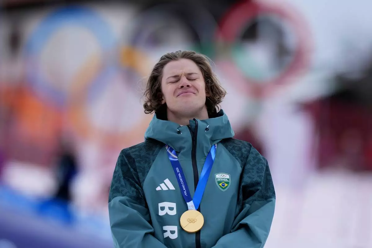 Brazil's Lucas Pinheiro Braathen listens to the national anthem as he wears his gold medal for an alpine ski, men's giant slalom race, at the 2026 Winter Olympics, in Bormio, Italy, Saturday, Feb. 14, 2026.(AP Photo/Julia Demaree Nikhinson)