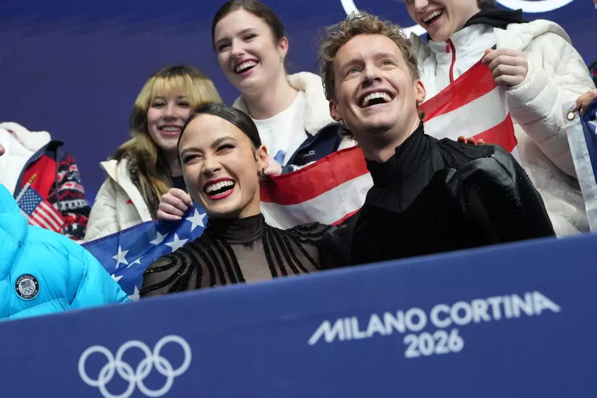 Madison Chock and Evan Bates of the United States react to their scores after competing during the figure skating ice dance team event at the 2026 Winter Olympics, in Milan, Italy, Saturday, Feb. 7, 2026. (AP Photo/Francisco Seco)