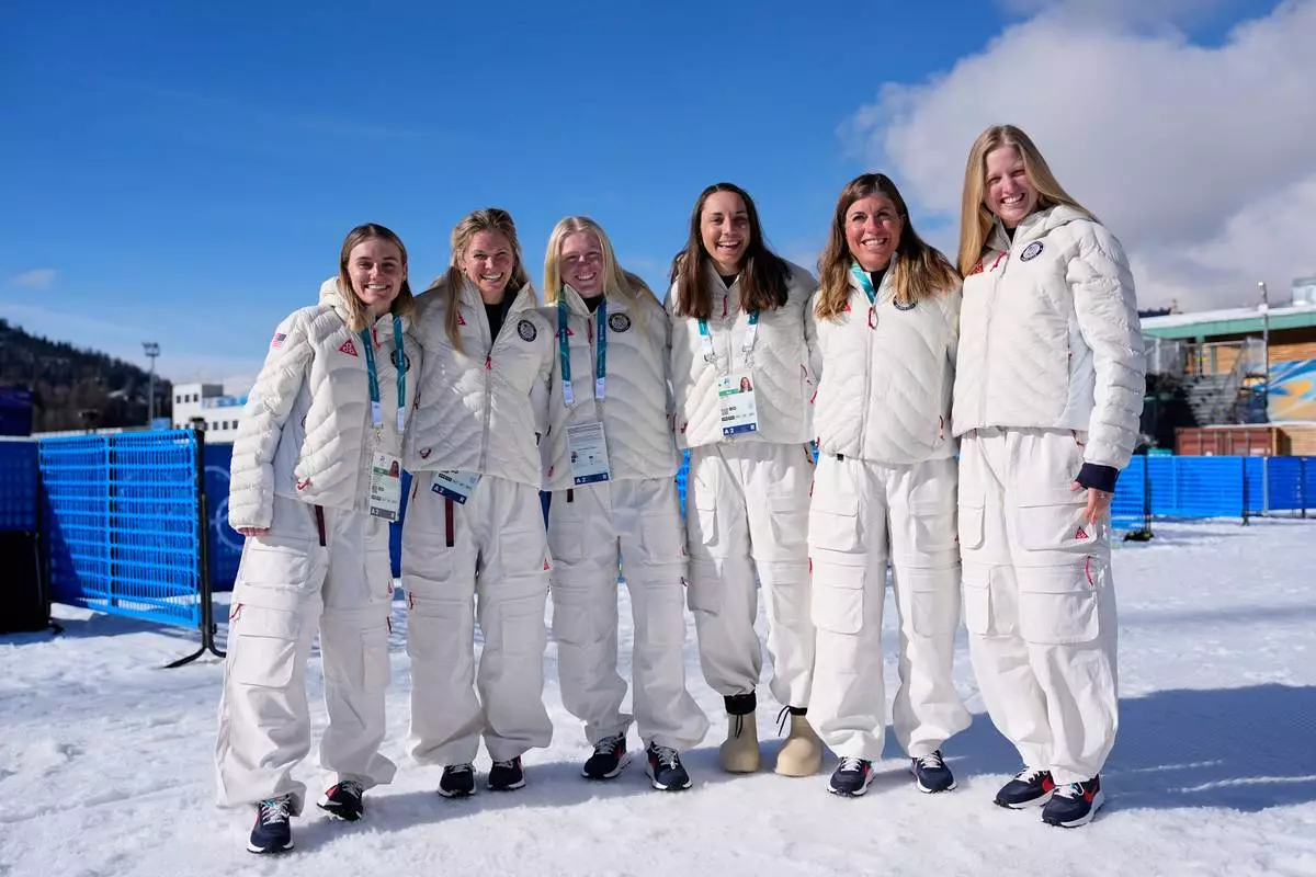 United States cross country athletes, from left, Novie McCabe, Jessie Diggins, Sammy Smith, Julia Kern, Rosie Brennan and Hayiley Swirlbul pose for photos before a cross country training session at the 2026 Winter Olympics, in Tesero, Italy, Thursday, Feb. 5, 2026. (AP Photo/Matthias Schrader)