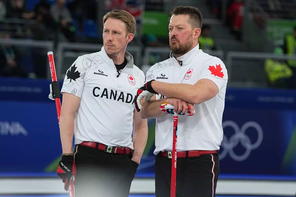 Canada's Marc Kennedy and Ben Hebert watch action in a men's curling semifinal match against Norway at the 2026 Winter Olympics, in Cortina d'Ampezzo, Italy, Thursday, Feb. 19, 2026. (AP Photo/Fatima Shbair)