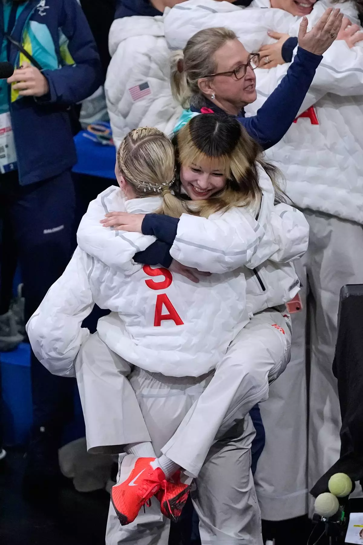 Alysa Liu hugs Amber Glenn after Team USA secured the gold medal in the figure skating team event at the 2026 Winter Olympics, in Milan, Italy, Sunday, Feb. 8, 2026. (AP Photo/Natacha Pisarenko)
