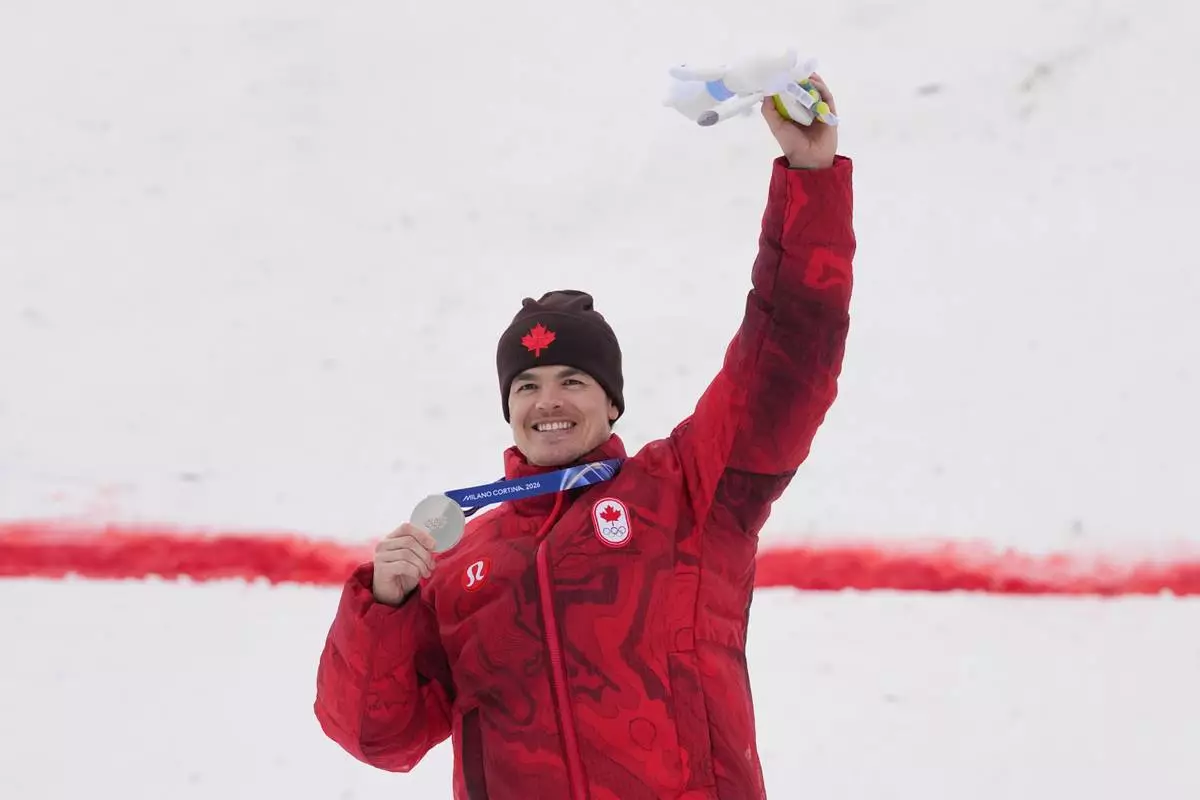 Canada's Mikael Kingsbury celebrates his silver medal in the men's freestyle skiing moguls finals at the 2026 Winter Olympics, in Livigno, Italy, Thursday, Feb. 12, 2026. (AP Photo/Gregory Bull)