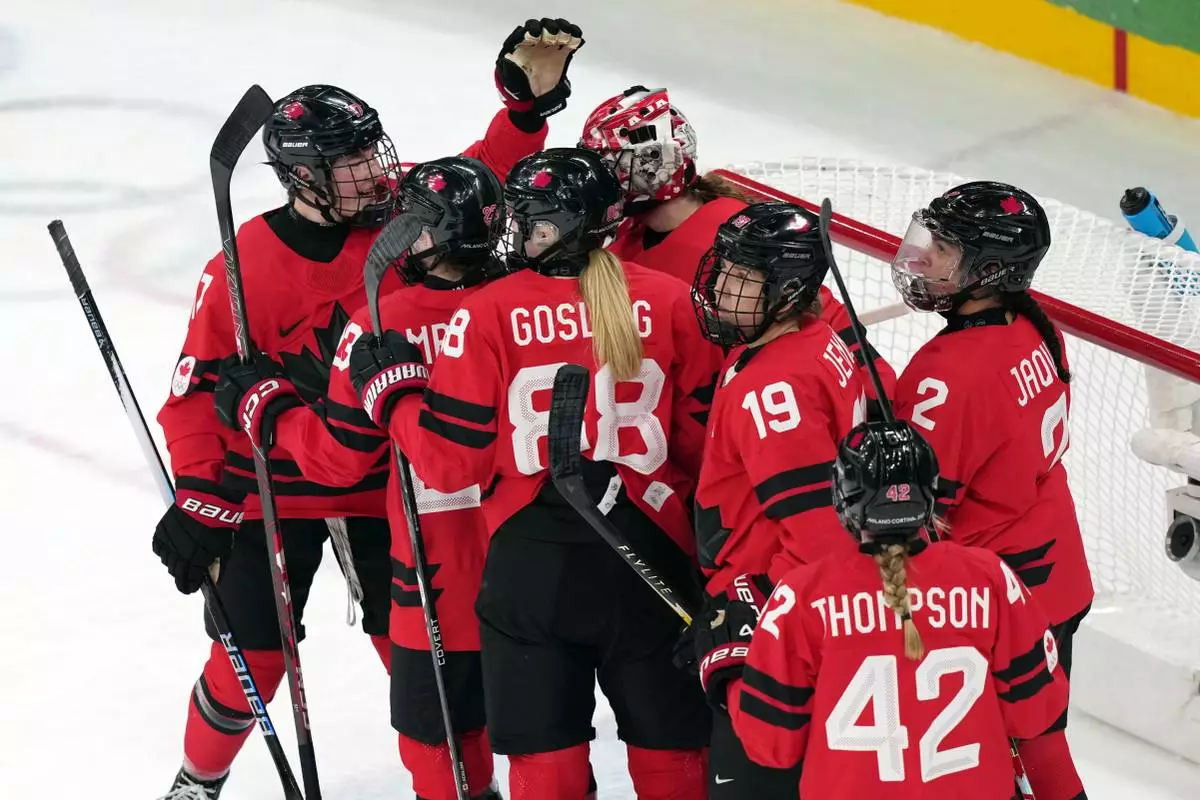 Team Canada players celebrate after their win over Switzerland in a women's ice hockey semifinal match at the 2026 Winter Olympics, in Milan, Italy, Monday, Feb. 16, 2026. (AP Photo/Carolyn Kaster)