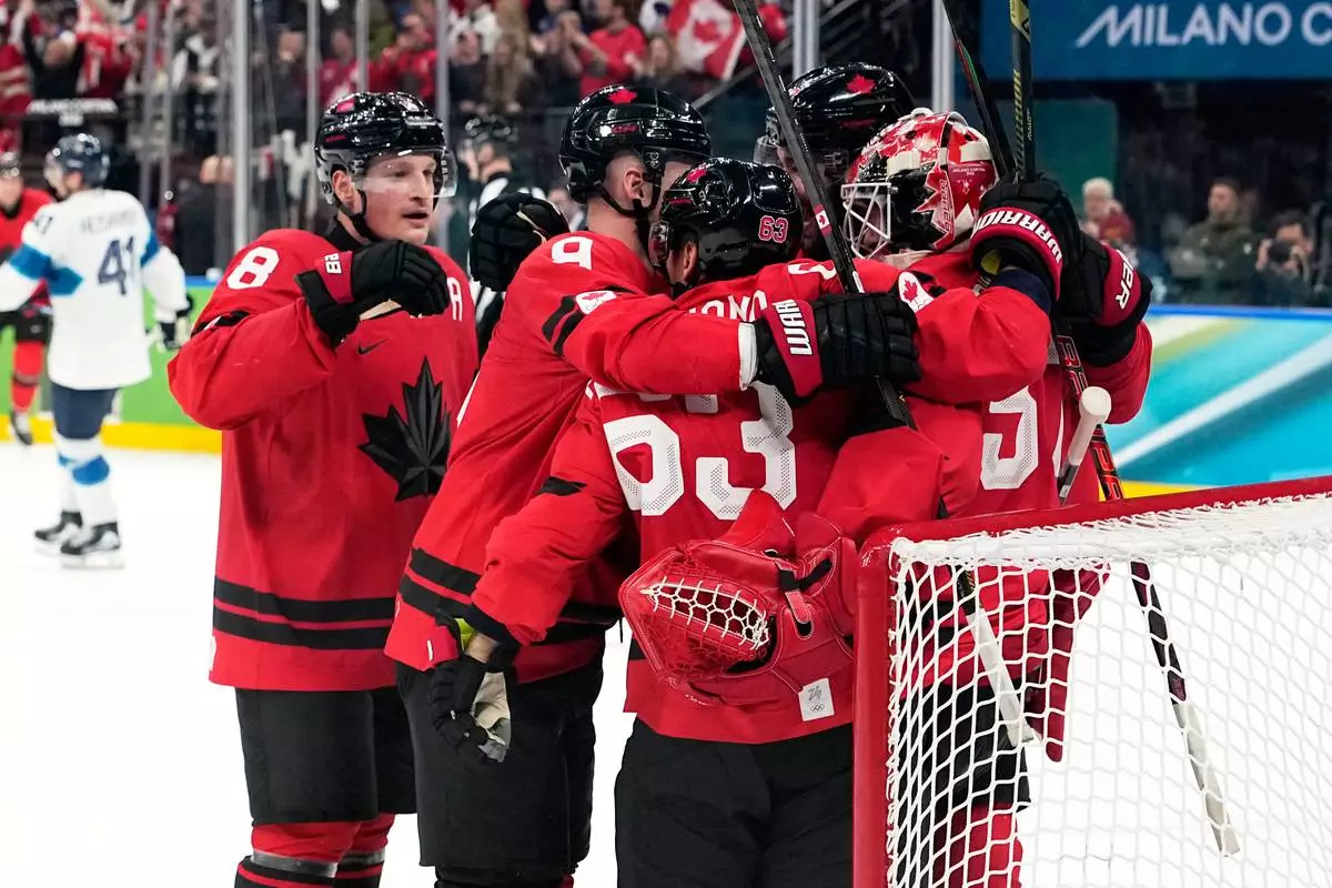 Canada players celebrate at the end of a men's ice hockey semifinal game between Canada and Finland at the 2026 Winter Olympics, in Milan, Italy, Friday, Feb. 20, 2026. (AP Photo/Hassan Ammar)