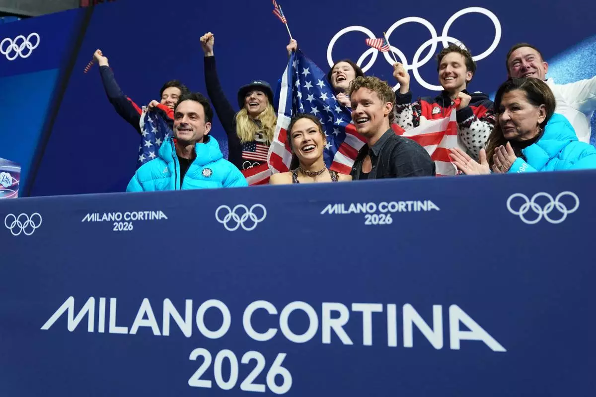 Madison Chock and Evan Bates of the United States react to their scores after competing during the figure skating ice dance team event at the 2026 Winter Olympics, in Milan, Italy, Friday, Feb. 6, 2026. (AP Photo/Stephanie Scarbrough)