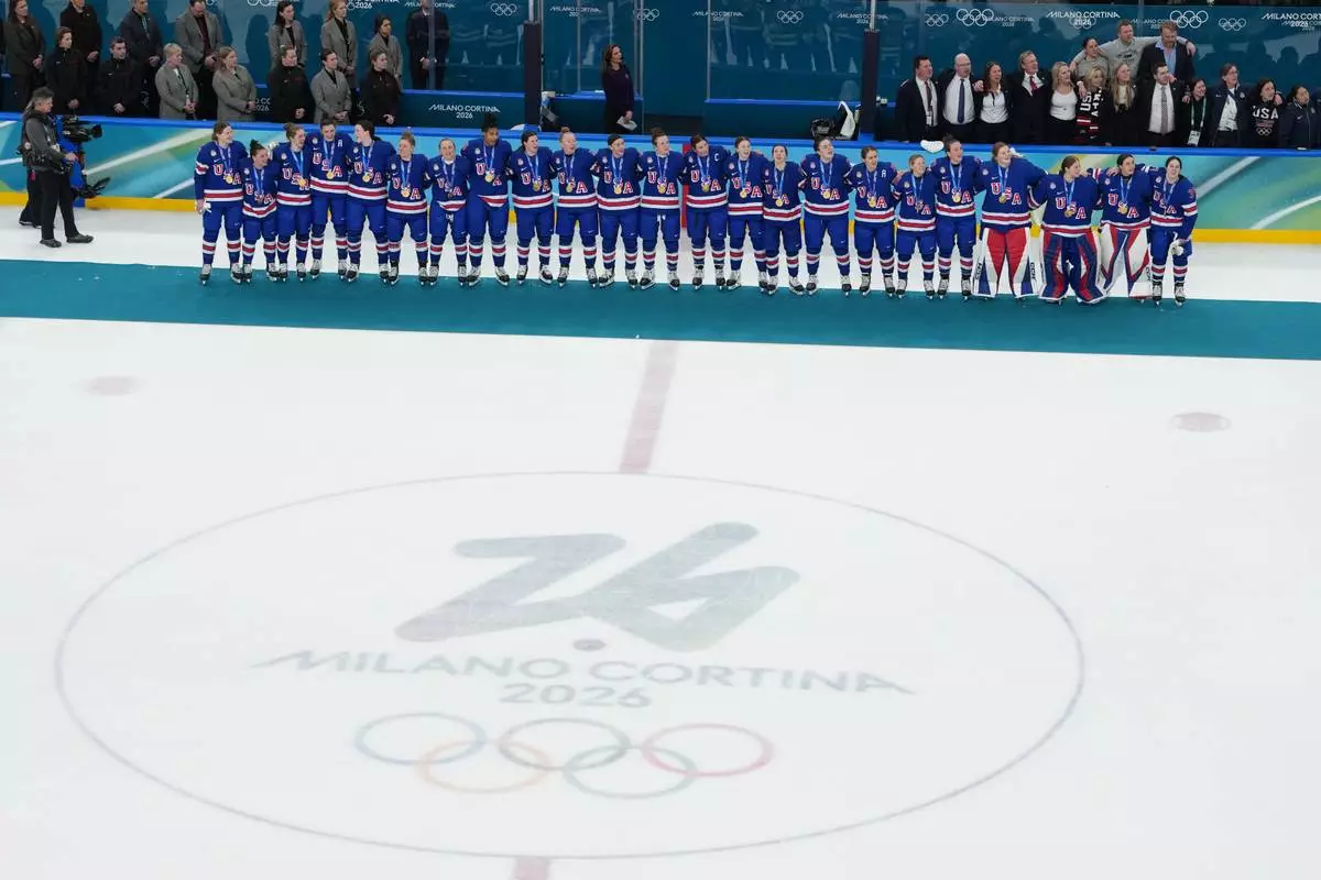 United States players and coaches stand during the playing of the national anthem after winning the women's ice hockey gold medal game at the 2026 Winter Olympics, in Milan, Italy, Thursday, Feb. 19, 2026. (AP Photo/Carolyn Kaster)