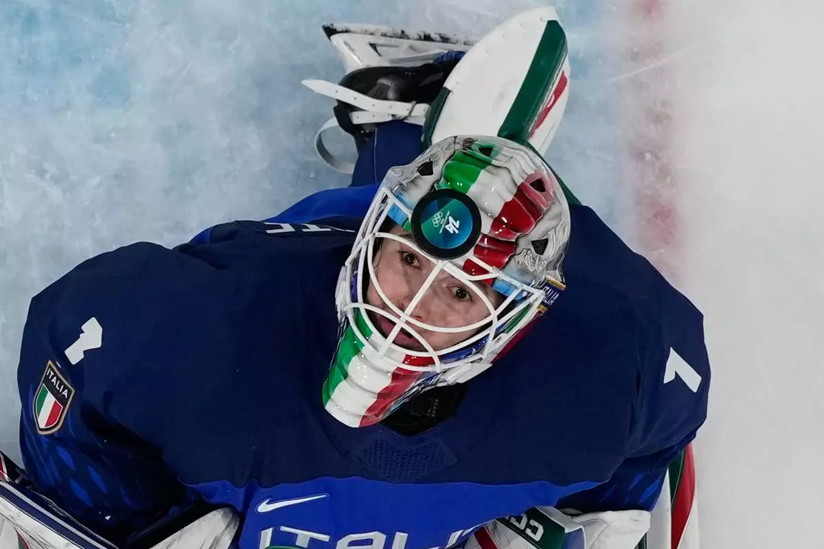 Italy's goalkeeper Gabriella Durante fails to save the puck as Japan's Akane Shiga scores her side's second goal during a preliminary round match of women's ice hockey between Japan and Italy at the 2026 Winter Olympics, in Milan, Italy, Feb. 9, 2026. (AP Photo/Hassan Ammar, File)