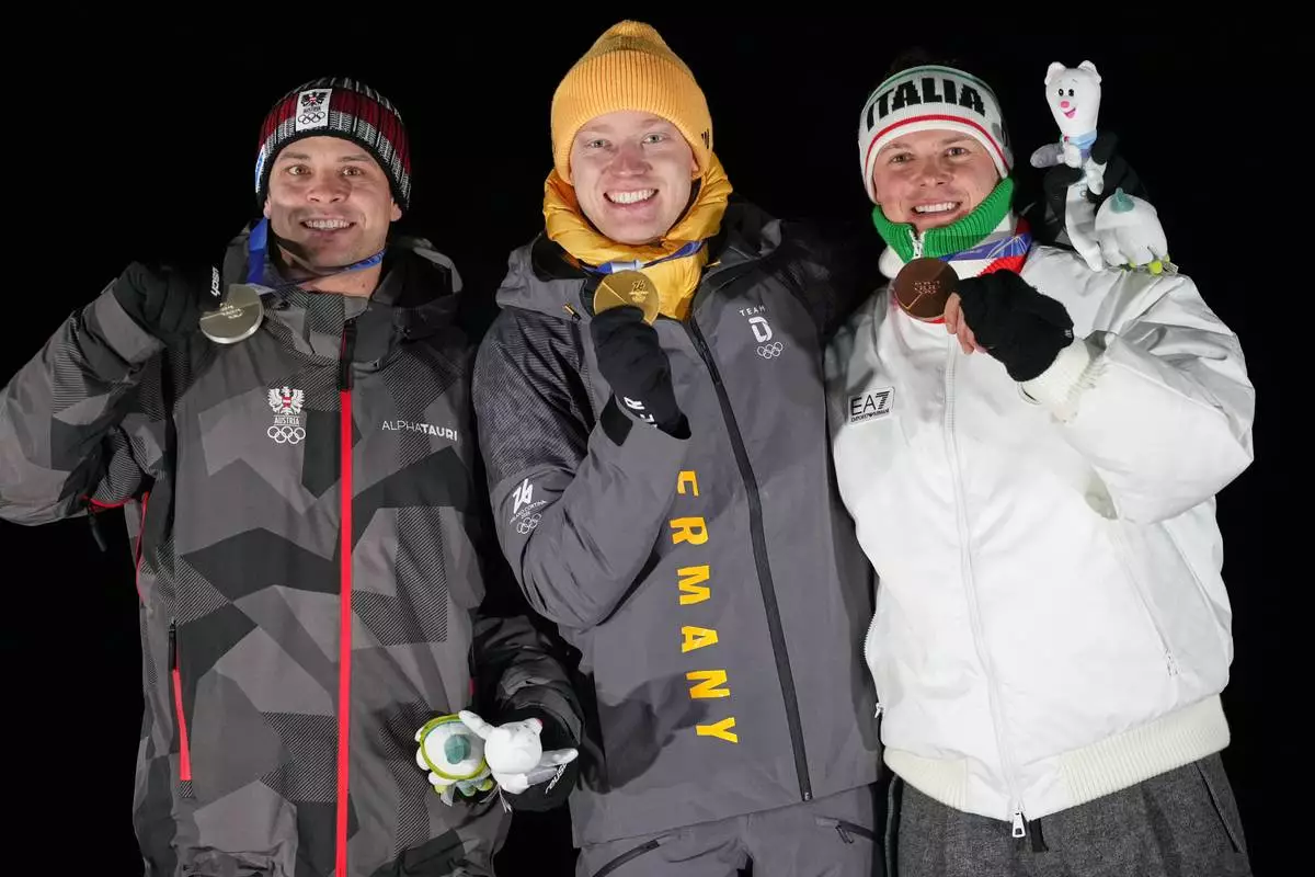 From left, second placed Austria's Jonas Mueller, first placed Germany's Max Langenhan and third placed Italy's Dominik Fischnaller pose with their medals after the men's single luge competition at the 2026 Winter Olympics, in Cortina d'Ampezzo, Italy, Sunday, Feb. 8, 2026. (AP Photo/Alessandra Tarantino)