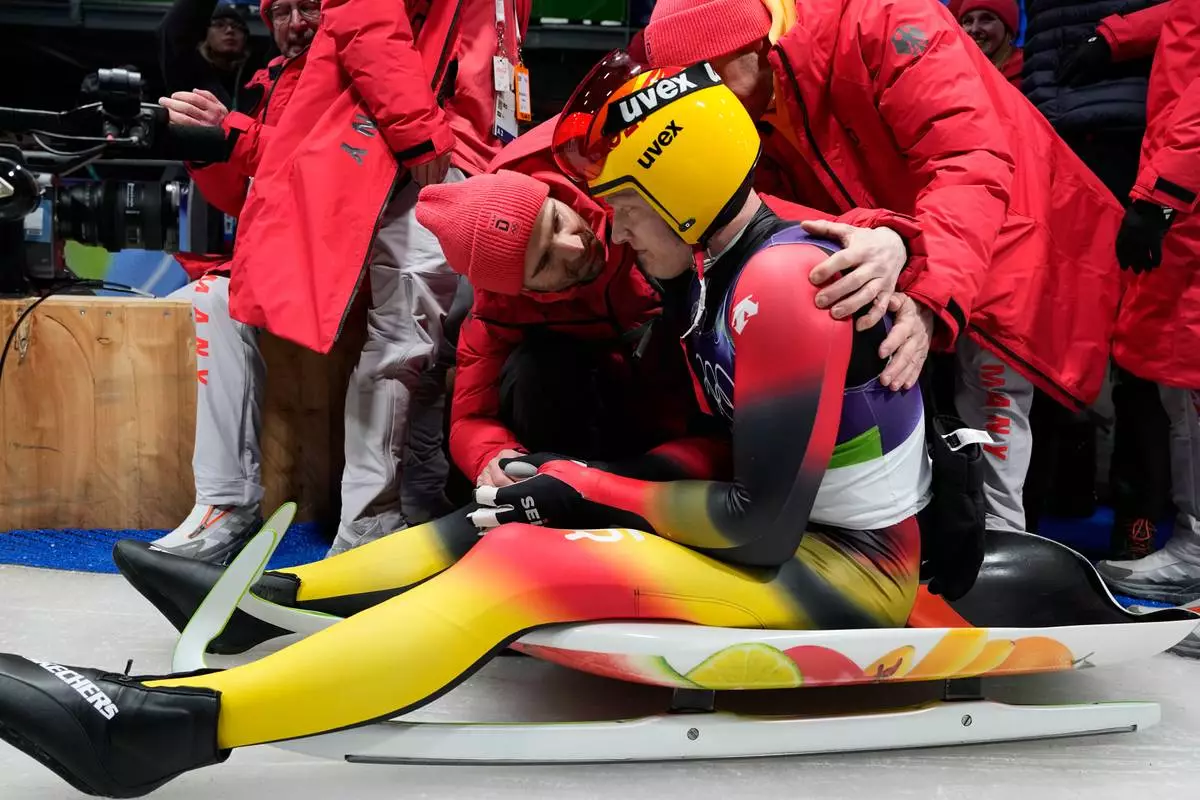 Germany's Max Langenhan reacts after winning the gold medal as he arrives at the finish during a men's single luge run at the 2026 Winter Olympics, in Cortina d'Ampezzo, Italy, Sunday, Feb. 8, 2026. (AP Photo/Alessandra Tarantino)