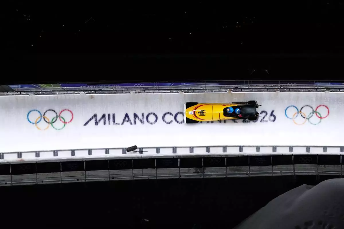 Germany's Francesco Friedrich and Alexander Schuller slide down the track during a two man bobsled run at the 2026 Winter Olympics, in Cortina d'Ampezzo, Italy, Tuesday, Feb. 17, 2026. (AP Photo/Alessandra Tarantino)