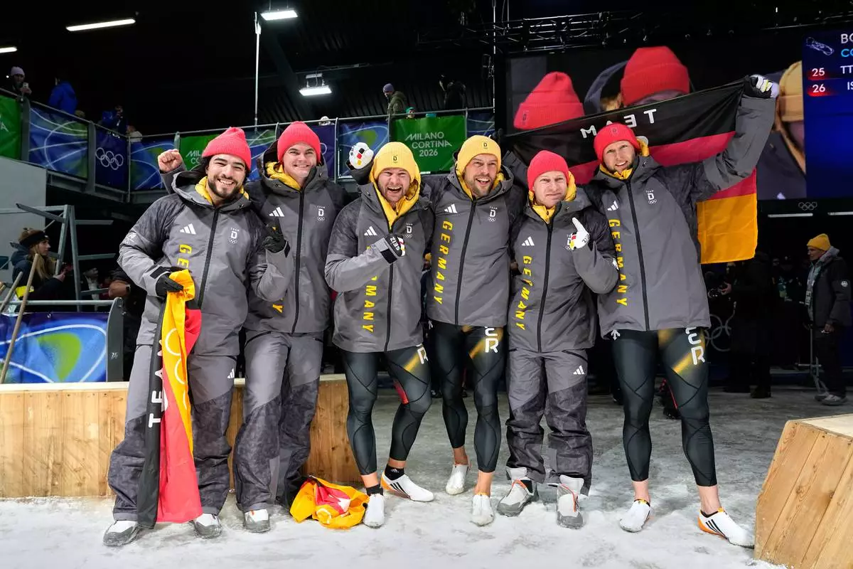 From left, Germany's bronze medalists Adam Ammour and Alexander Schaller, Germany's gold medalists Johannes Lochner and Georg Fleischhauer and Germany's silver medalists Francesco Friedrich and Alexander Schuller celebrate at the finish after the two man bobsled competition at the 2026 Winter Olympics, in Cortina d'Ampezzo, Italy, Tuesday, Feb. 17, 2026. (AP Photo/Alessandra Tarantino)