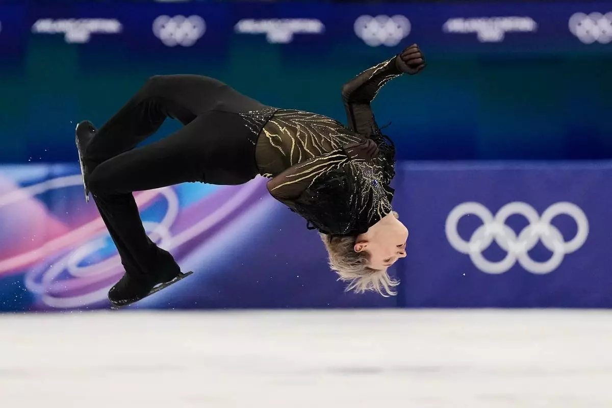 Ilia Malinin of the United States does a back flip while competing during the men's free skate program in figure skating at the 2026 Winter Olympics, in Milan, Italy, Friday, Feb. 13, 2026. (AP Photo/Ashley Landis)