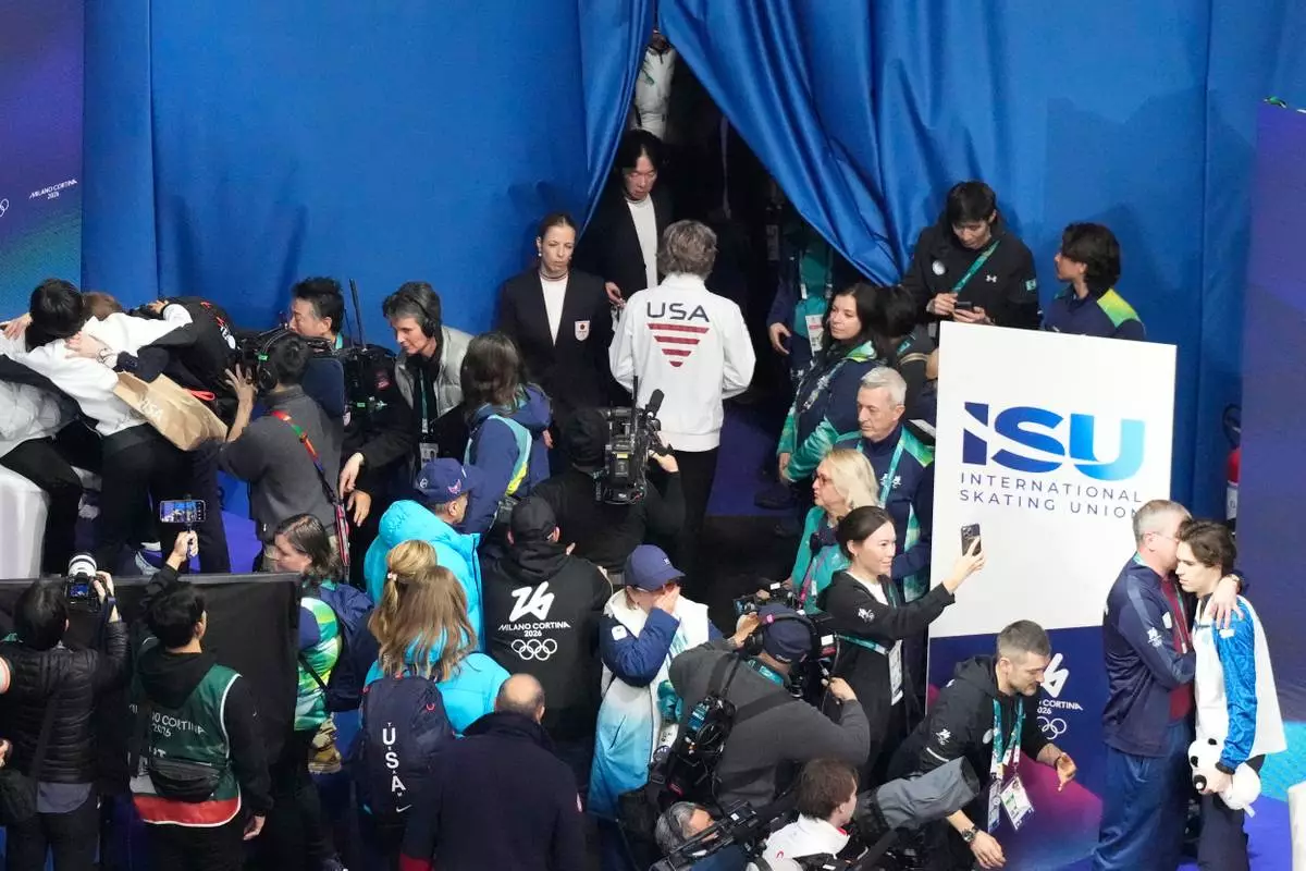 Ilia Malinin of the United States, center, leaves after the men's free skate program in figure skating at the 2026 Winter Olympics, in Milan, Italy, Friday, Feb. 13, 2026. (AP Photo/Christophe Ena)