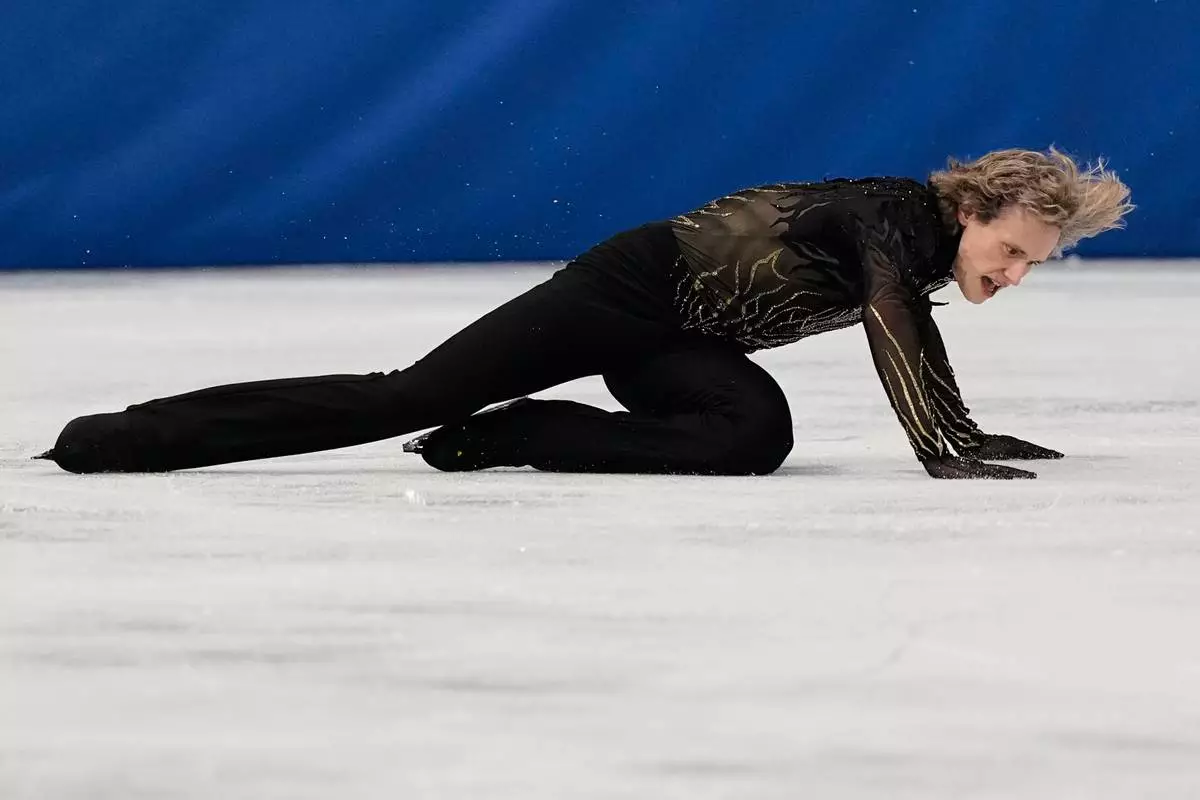Ilia Malinin of the United States falls during the men's free skate program in figure skating at the 2026 Winter Olympics, in Milan, Italy, Friday, Feb. 13, 2026. (AP Photo/Ashley Landis)