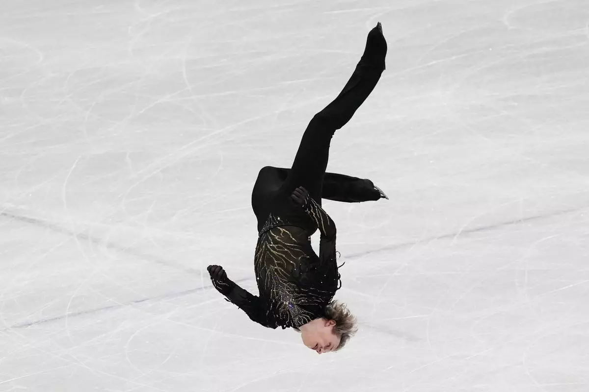 Ilia Malinin of the United States does a back flip while competing during the men's free skate program in figure skating at the 2026 Winter Olympics, in Milan, Italy, Friday, Feb. 13, 2026. (AP Photo/Stephanie Scarbrough)