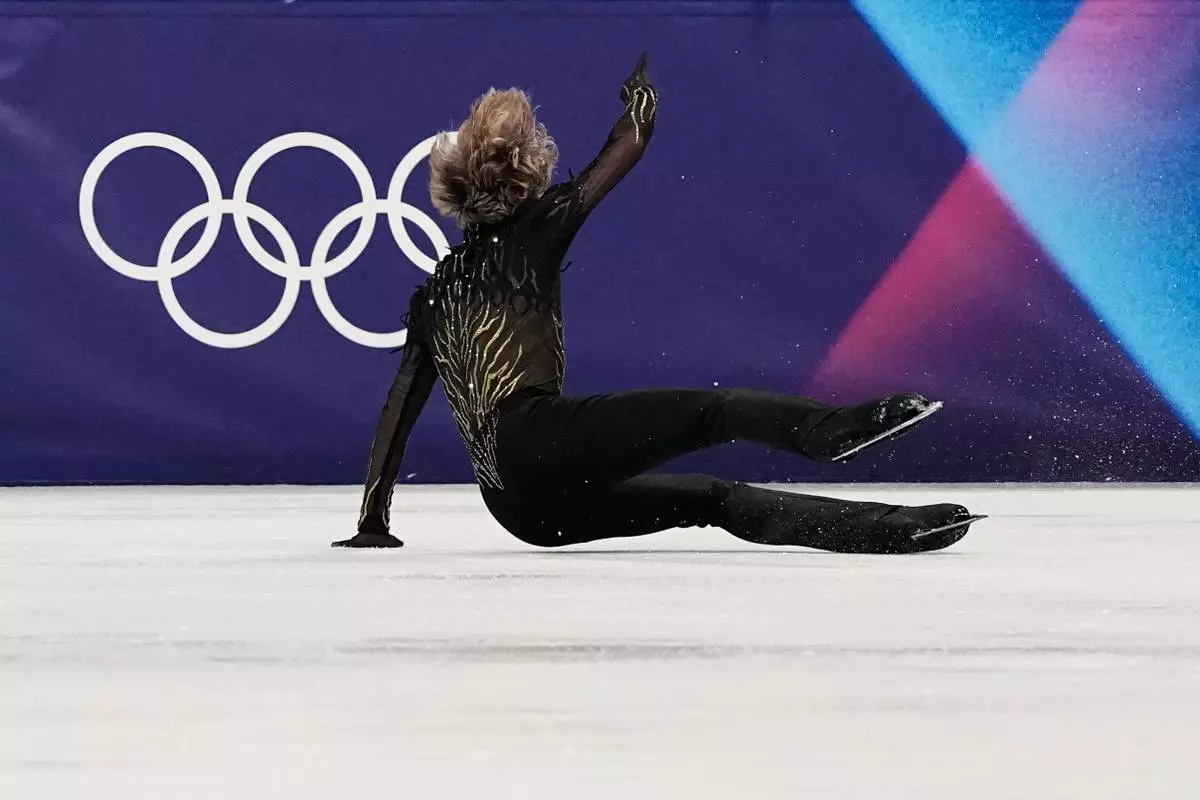 Ilia Malinin of the United States falls during the men's free skate program in figure skating at the 2026 Winter Olympics, in Milan, Italy, Friday, Feb. 13, 2026. (AP Photo/Ashley Landis)