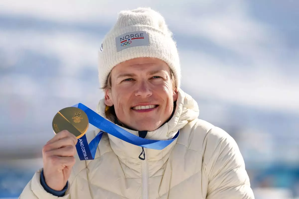 Johannes Hoesflot Klaebo, of Norway, poses after winning the gold medal in the cross country skiing men's 10km + 10km skiathlon at the 2026 Winter Olympics, in Tesero, Italy, Sunday, Feb. 8, 2026. (AP Photo/Kirsty Wigglesworth)