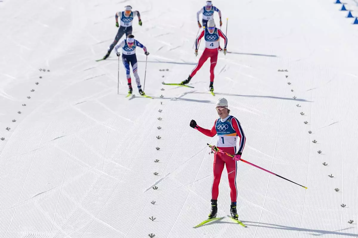 Johannes Hoesflot Klaebo, of Norway, approaches the finish line to win the gold medal in the cross country skiing men's 10km + 10km skiathlon at the 2026 Winter Olympics, in Tesero, Italy, Sunday, Feb. 8, 2026. (AP Photo/Matthias Schrader)