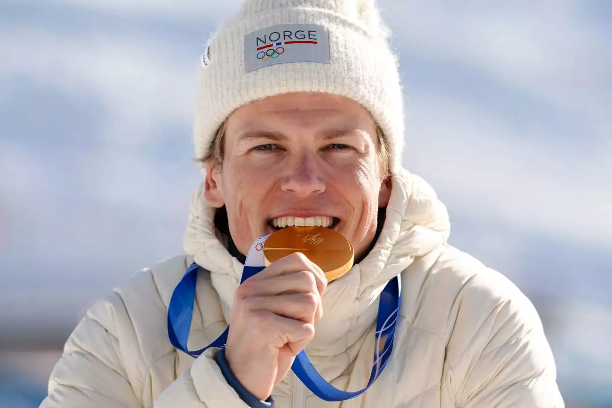 Johannes Hoesflot Klaebo, of Norway, poses after winning the gold medal in the cross country skiing men's 10km + 10km skiathlon at the 2026 Winter Olympics, in Tesero, Italy, Sunday, Feb. 8, 2026. (AP Photo/Kirsty Wigglesworth)
