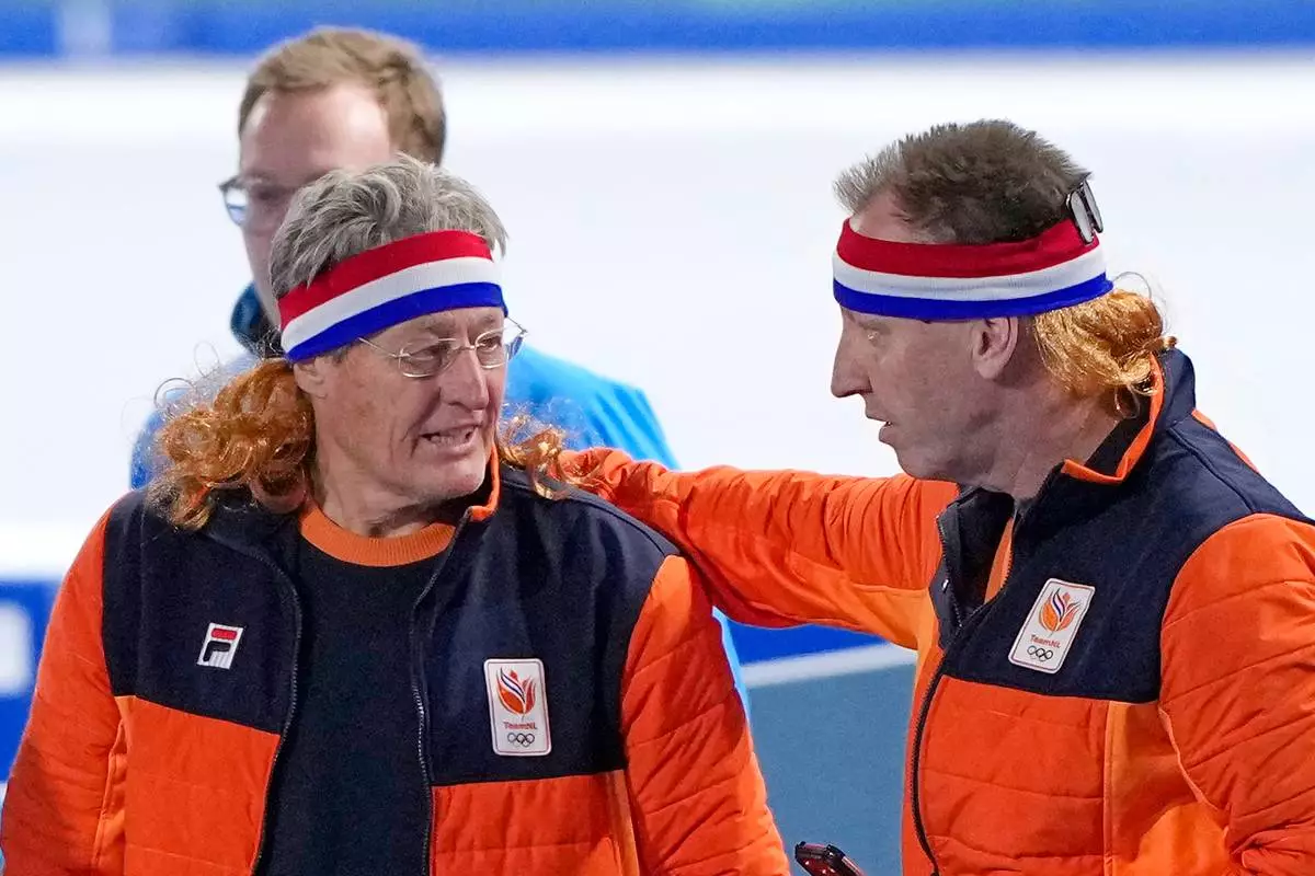 Dutch coach Jillert Anema wears a mullet honouring the bronze medal of Jorrit Bergsma of the Netherlands after the men's 10,000 meters speedskating race at the 2026 Winter Olympics, in Milan, Italy, Friday, Feb. 13, 2026. (AP Photo/Ben Curtis)