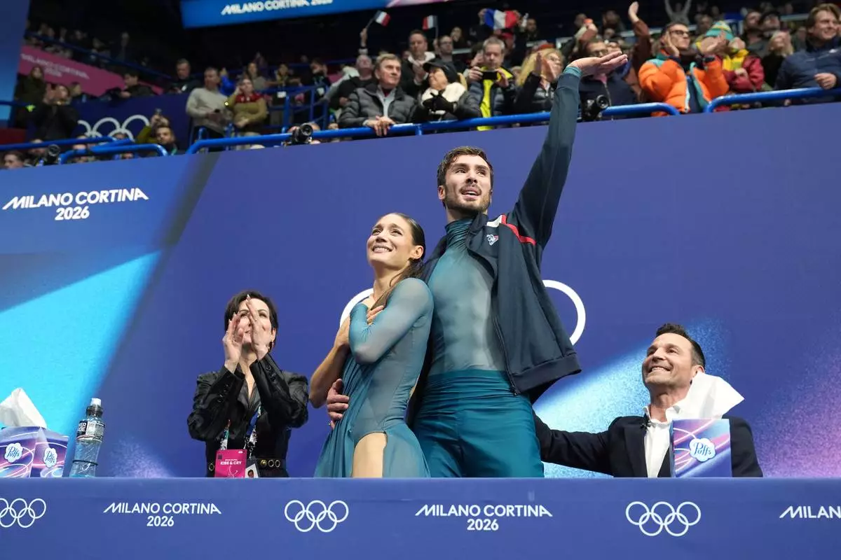 Laurence Fournier Beaudry and Guillaume Cizeron of France react to their scores that earned them the gold medal after competing during the ice dancing free skate in figure skating at the 2026 Winter Olympics, in Milan, Italy, Wednesday, Feb. 11, 2026. (AP Photo/Stephanie Scarbrough)