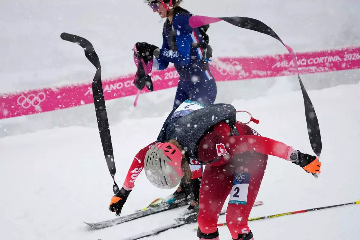 Switzerland's Marianne Fatton strips off her skins during a ski mountaineering women's semifinal at the 2026 Winter Olympics, in Bormio, Italy, Thursday, Feb. 19, 2026. (AP Photo/John Locher)