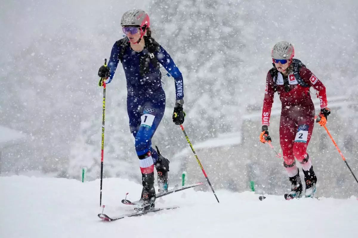 France's Emily Harrop, left, is followed by Switzerland's Marianne Fatton during a ski mountaineering women's semifinal at the 2026 Winter Olympics, in Bormio, Italy, Thursday, Feb. 19, 2026. (AP Photo/John Locher)