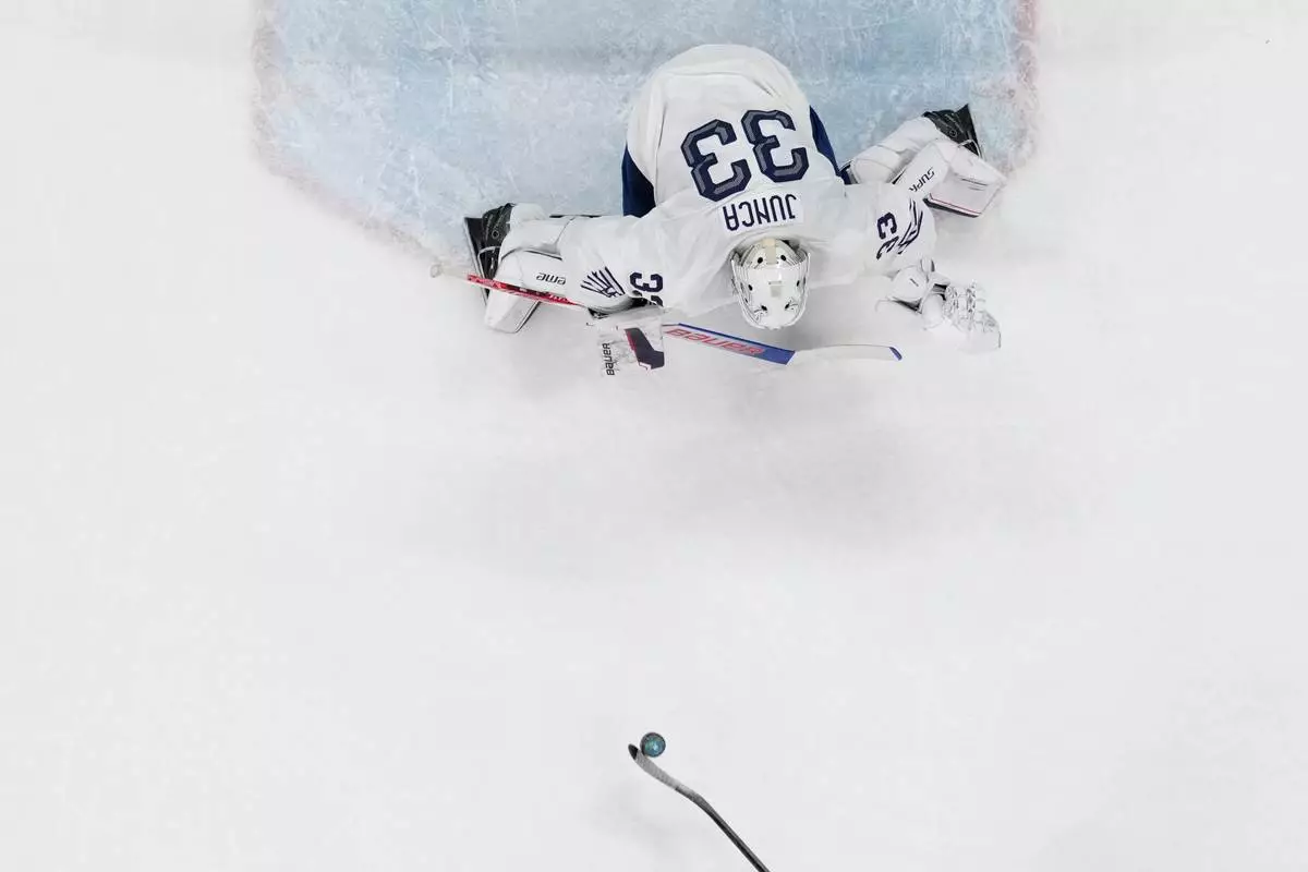 Canada's Macklin Celebrini (17) scores on a penalty shot against France's goalkeeper Julian Junca (33) in the second period during a preliminary round game of men's ice hockey between Canada and France at the 2026 Winter Olympics, in Milan, Italy, Sunday, Feb. 15, 2026. (AP Photo/Carolyn Kaster)