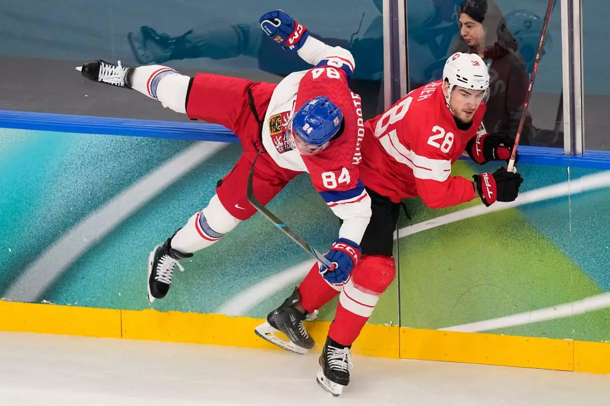 Czechia's Tomas Kundratek (84) challenges with Switzerland's Timo Meier (28) during a preliminary round match of men's ice hockey between Switzerland and Czechia at the 2026 Winter Olympics, in Milan, Italy, Sunday, Feb. 15, 2026. (AP Photo/Petr David Josek)