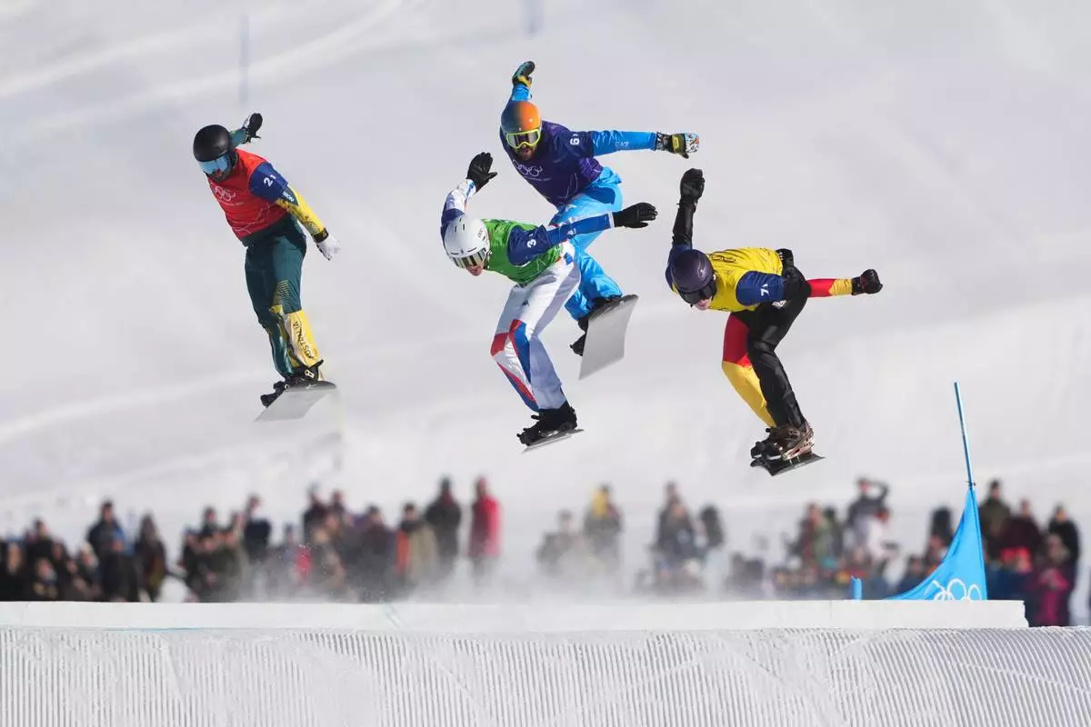 From left, Australia's Adam Lambert (2-1), France's Aidan Chollet (3-1), Italy's Lorenzo Sommariva (6-1) and Germany's Leon Ulbricht (7-1) compete during the mixed team snowboard cross finals at the 2026 Winter Olympics, in Livigno, Italy, Sunday, Feb. 15, 2026. (AP Photo/Lindsey Wasson)