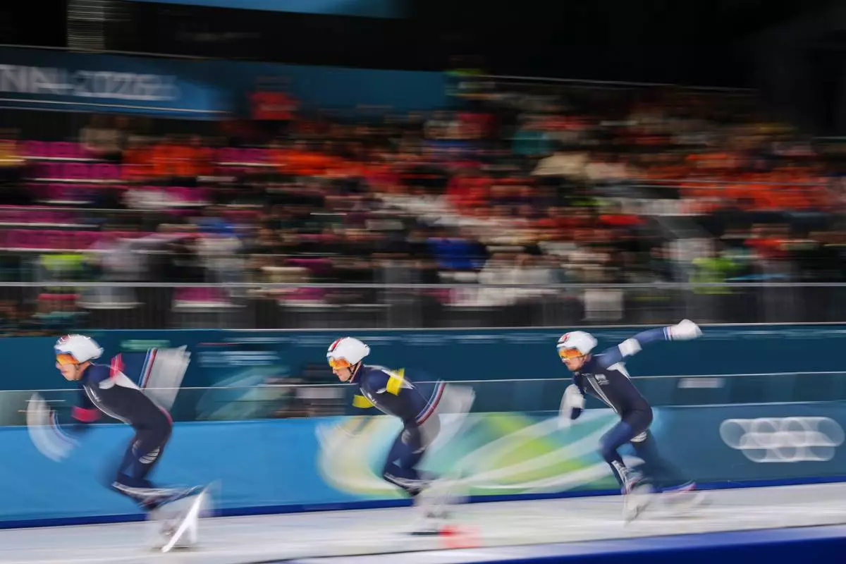 Team France with Germain Deschamps, white armband, Timothy Loubineaud, red armband, and Valentin Thiebault, yellow armband, compete in the men's team pursuit quarterfinals speedskating race at the 2026 Winter Olympics, in Milan, Italy, Sunday, Feb. 15, 2026. (AP Photo/Antonio Calanni)