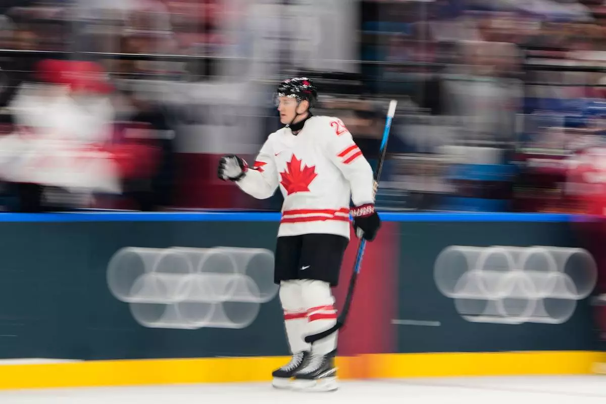 Canada's Nathan MacKinnon celebrates after scoring his sides fourth goal during a preliminary round match of men's ice hockey between Czech Republic and Canada at the 2026 Winter Olympics, in Milan, Italy, Thursday, Feb. 12, 2026. (AP Photo/Petr David Josek)