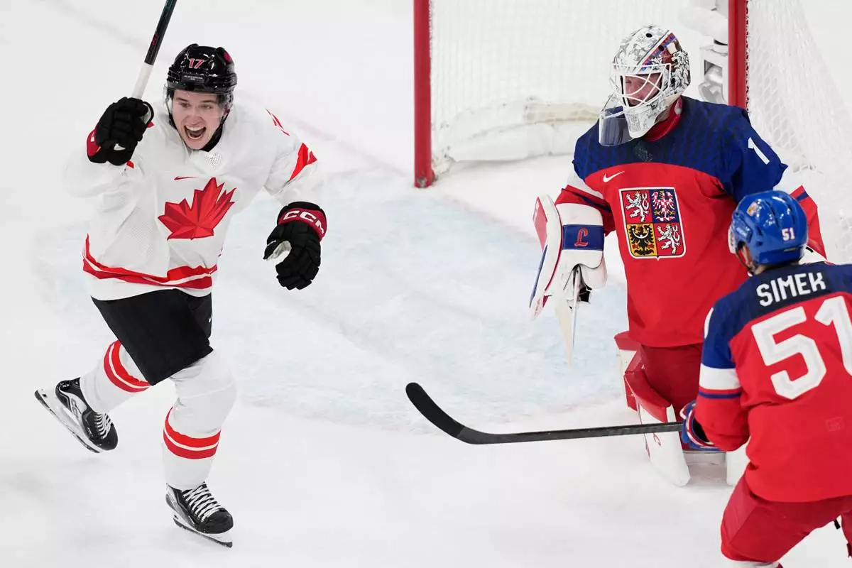 during a preliminary round match of men's ice Canada's Macklin Celebrini celebrates after scoring his sides first goal past Czechia's goalkeeper Lukas Dostal hockey between Czech Republic and Canada at the 2026 Winter Olympics, in Milan, Italy, Thursday, Feb. 12, 2026. (AP Photo/Petr David Josek)