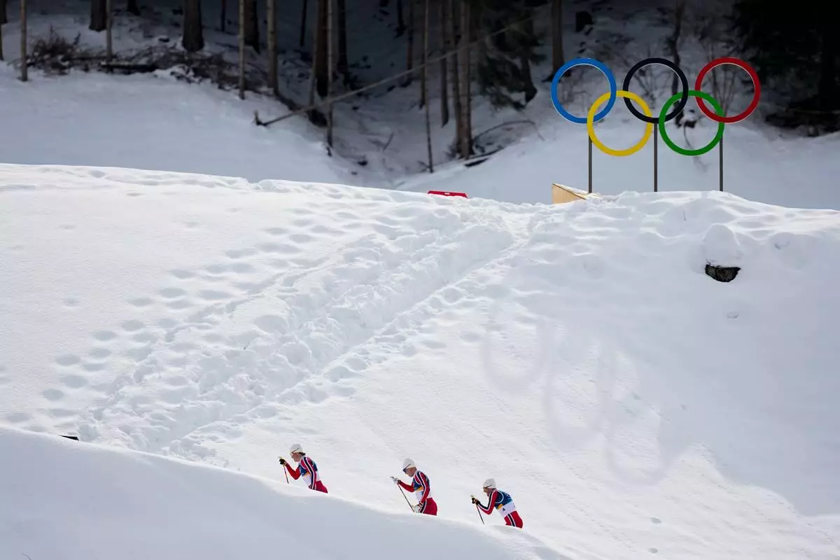 Johannes Hoesflot Klaebo, from left, Martin Loewstroem Nyenget and Emil Iversen, all three of Norway, compete in the cross country skiing men's 50km mass start Classic at the 2026 Winter Olympics, in Tesero, Italy, Saturday, Feb. 21, 2026. (AP Photo/Matthias Schrader)