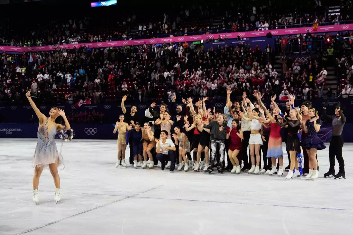 Athletes take a group selfie after performing in the figure skating exhibition at the 2026 Winter Olympics, in Milan, Italy, Saturday, Feb. 21, 2026. (AP Photo/Ashley Landis)