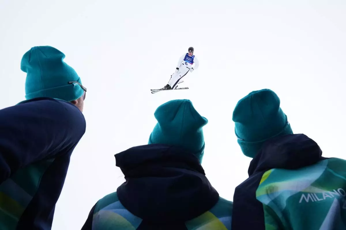 Workers watch as United States' Kaila Kuhn (5-1) practices before the freestyle skiing mixed team aerials final at the 2026 Winter Olympics, in Livigno, Italy, Saturday, Feb. 21, 2026. (AP Photo/Gregory Bull)