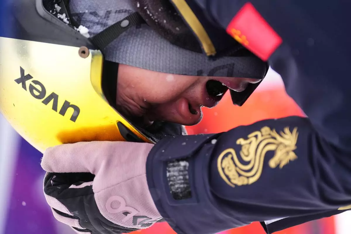 China's Li Tianma (1-3) reacts after crashing during the freestyle skiing mixed team aerials final at the 2026 Winter Olympics, in Livigno, Italy, Saturday, Feb. 21, 2026. (AP Photo/Lindsey Wasson)
